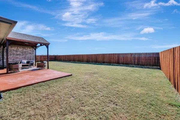 a view of a house with table and chairs in patio