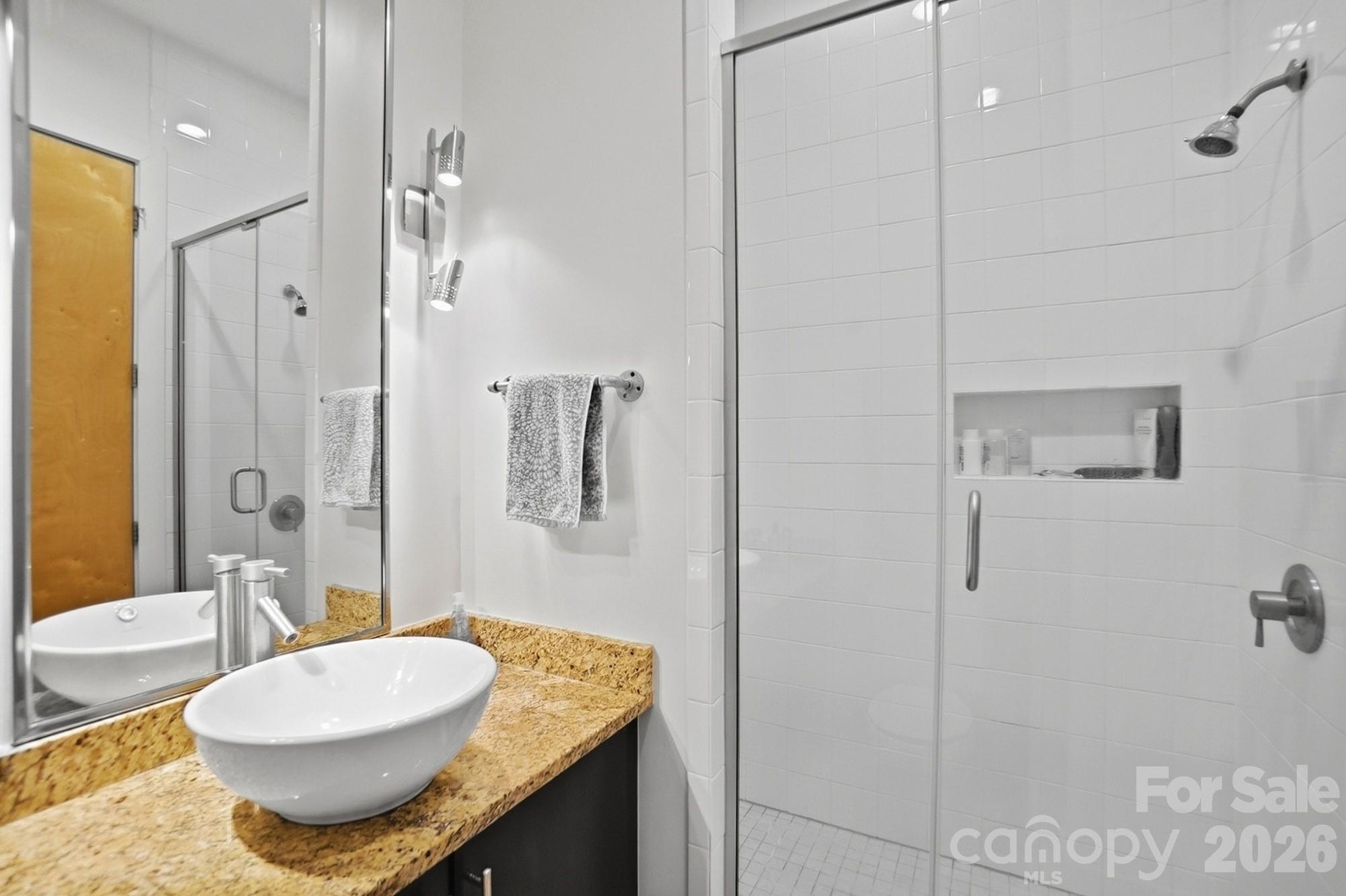 2116 McClintock Road, Unit 221 Charlotte, NC 28205 - Photo 24 of 44 a bathroom with a granite countertop sink a toilet and shower