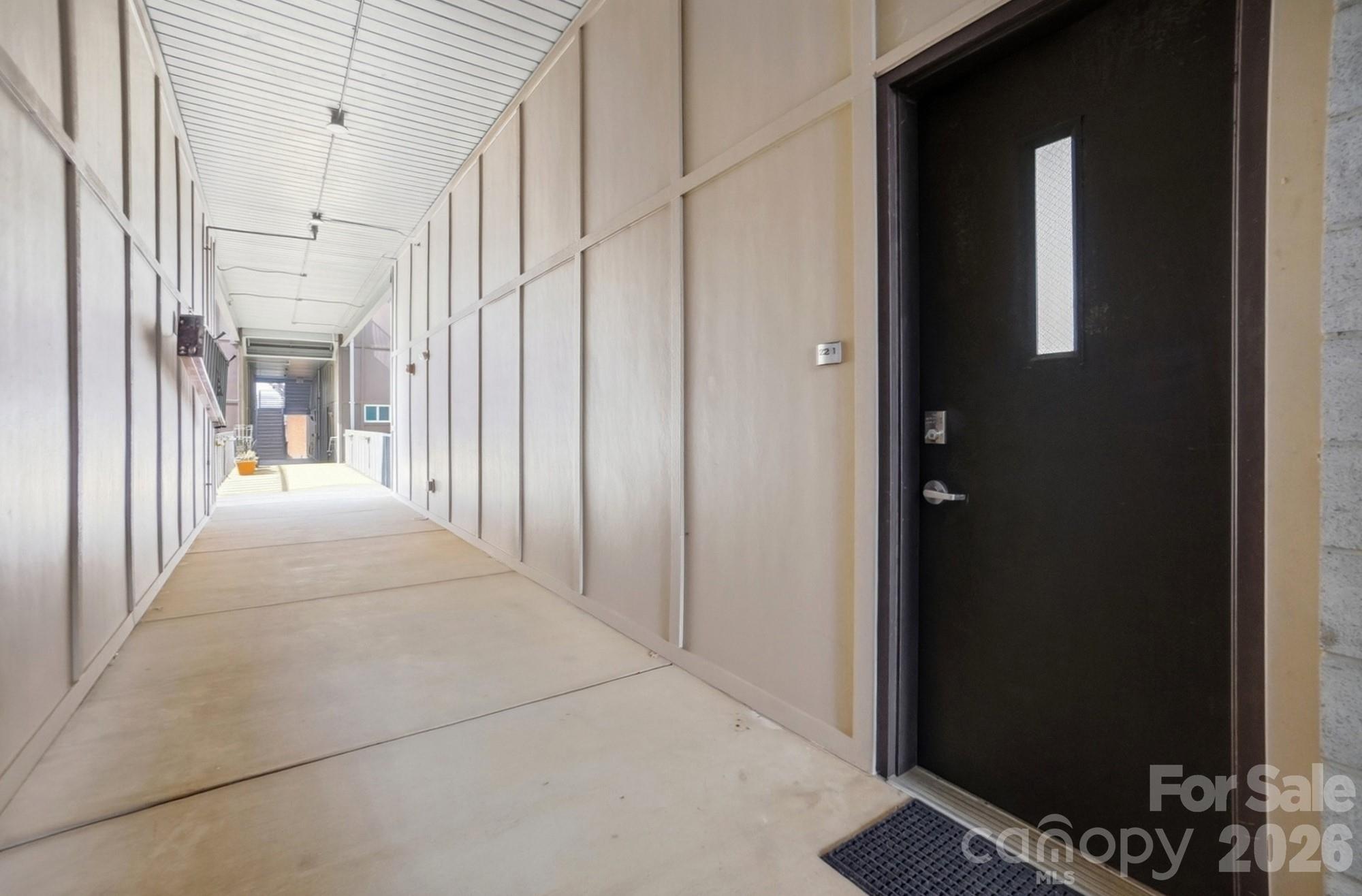2116 McClintock Road, Unit 221 Charlotte, NC 28205 - Photo 5 of 44 a view of a hallway with wooden floor and a living room