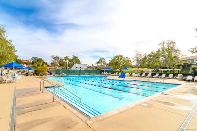 a view of a swimming pool with outdoor seating and plants