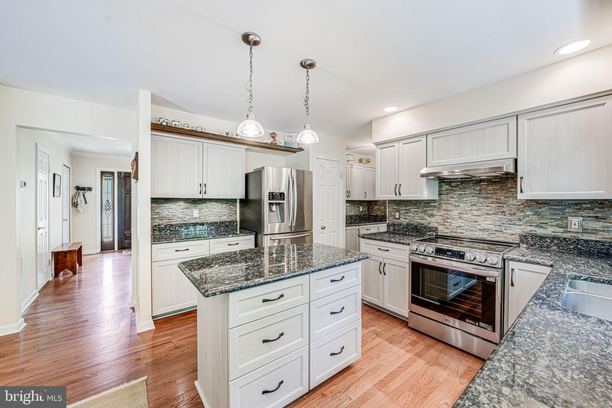 9802 Natick Road Burke, VA 22015 - Photo 14 of 45 a kitchen with stainless steel appliances granite countertop a stove a sink and a refrigerator
