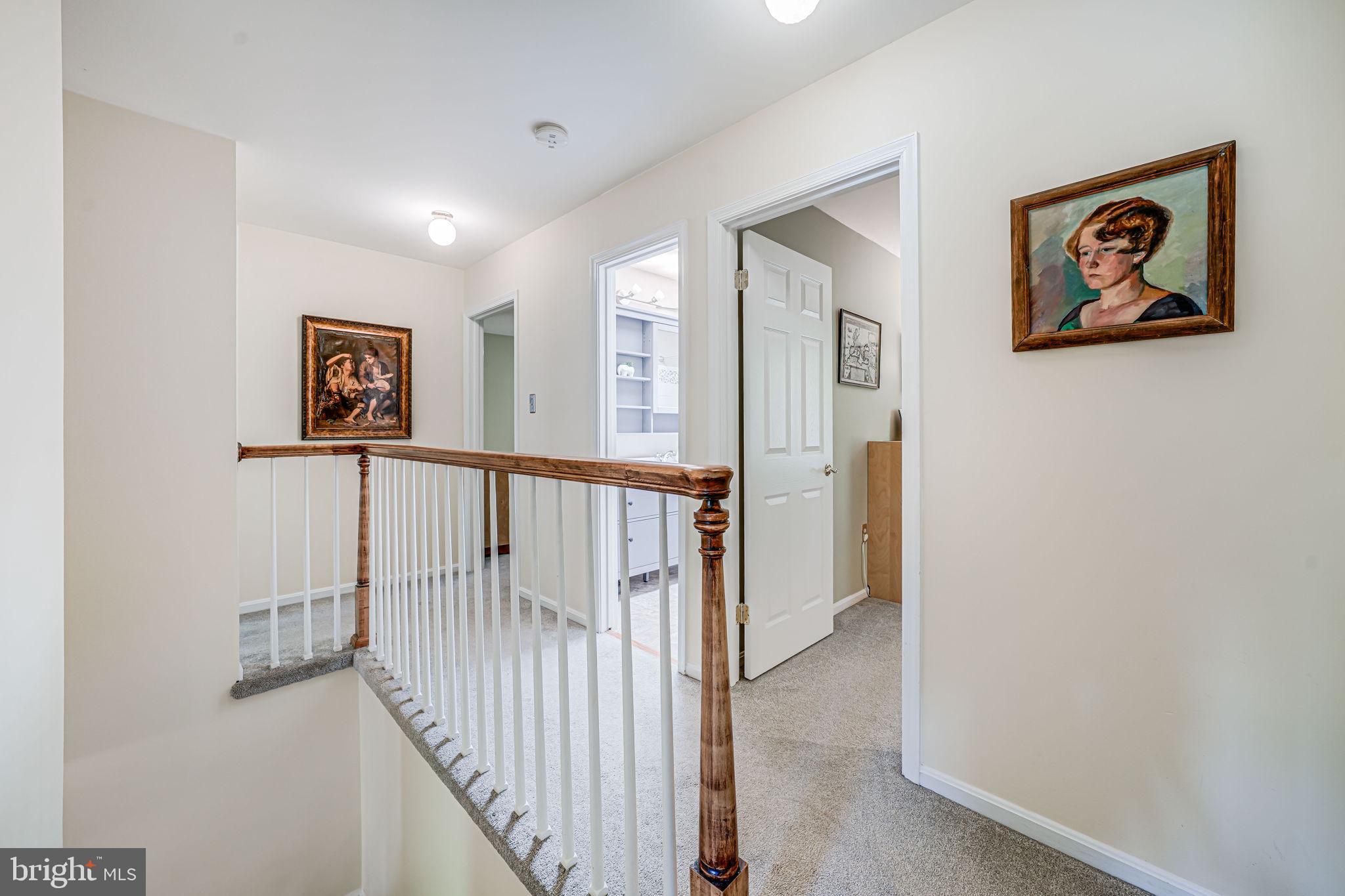 9802 Natick Road Burke, VA 22015 - Photo 21 of 45 a view of a hallway with paintings on the wall