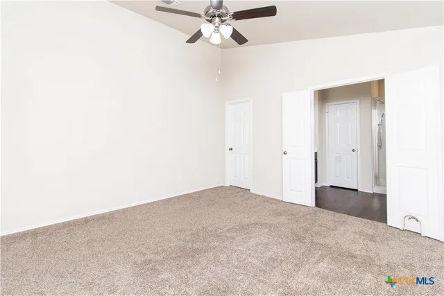 a view of empty room with a ceiling fan