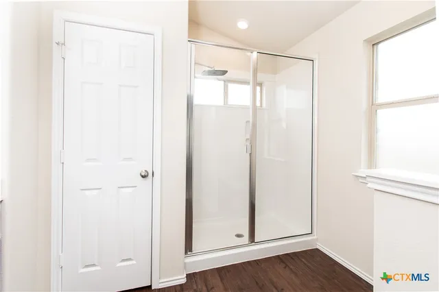 a bathroom with a glass shower door