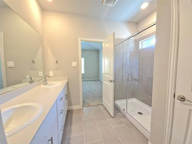 a spacious bathroom with a granite countertop sink a mirror and a bathtub