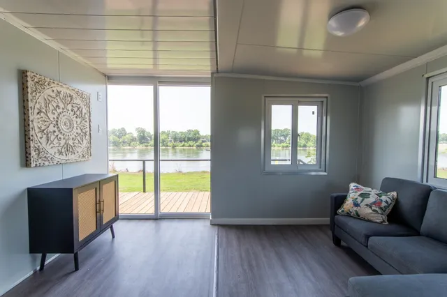 a living room with furniture a window and wooden floor