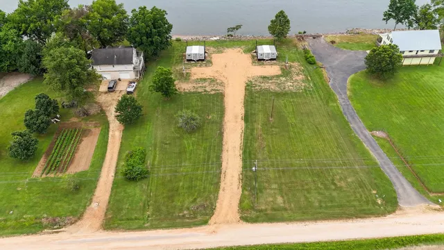 an aerial view of a house with a yard and lake view
