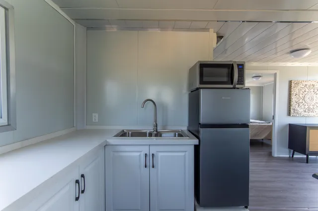 a kitchen with stainless steel appliances a dining table chairs and granite counter tops