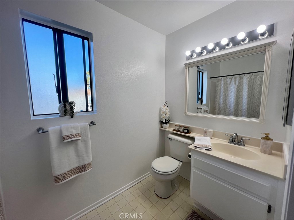 3516 East Ransom Street, Unit 204 Long Beach, CA 90804 - Photo 7 of 38 a bathroom with a toilet sink and mirror