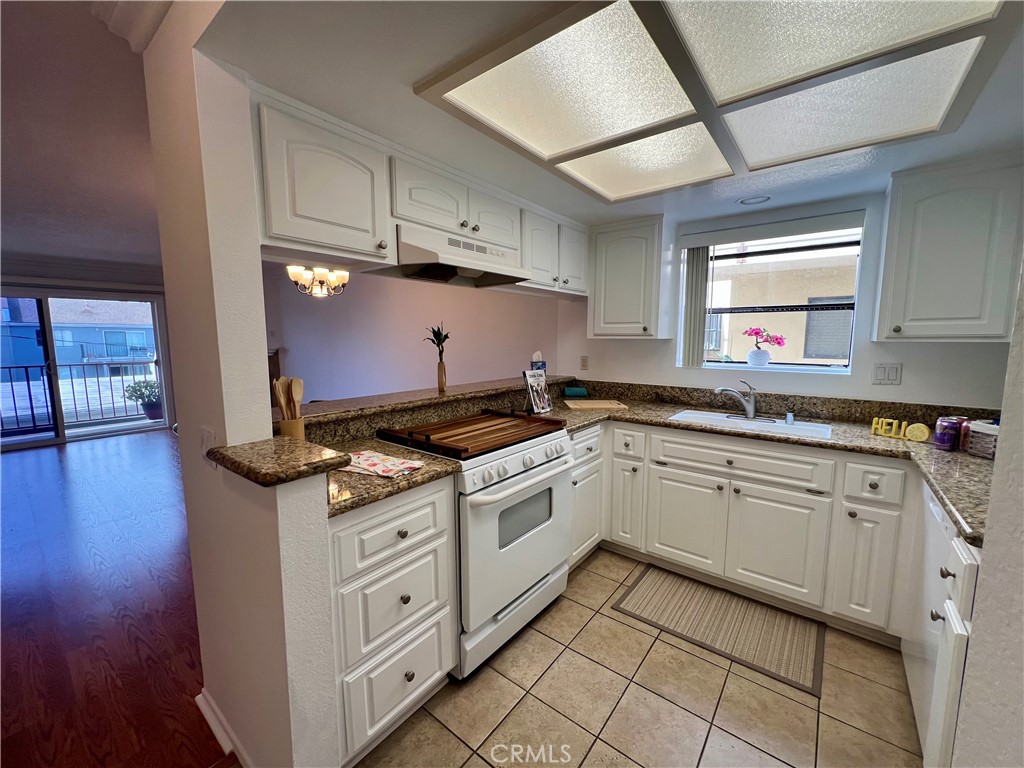 3516 East Ransom Street, Unit 204 Long Beach, CA 90804 - Photo 10 of 38 a kitchen with cabinets appliances and a wooden floor