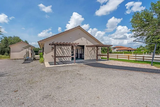 a view of a house with a yard and large trees