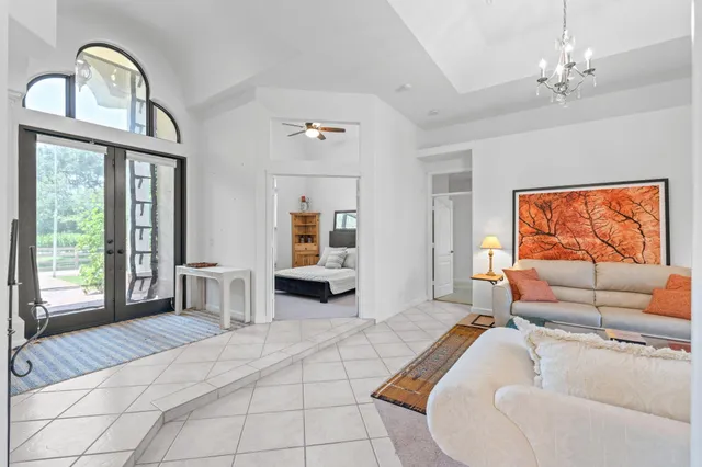 a bedroom with a bed chandelier and a window