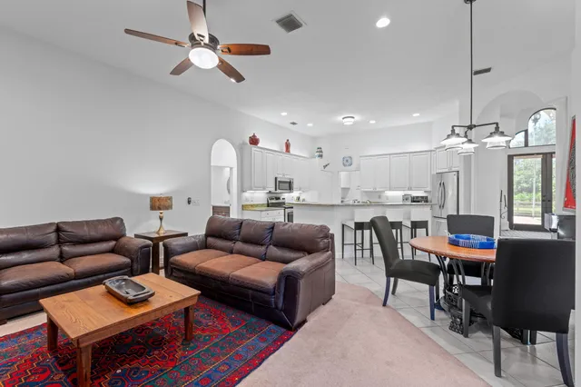 a bedroom with a bed chandelier and a window