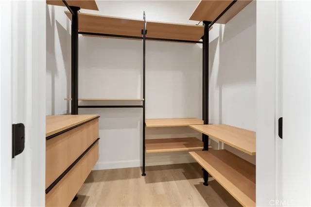 a view of walk in closet with empty racks