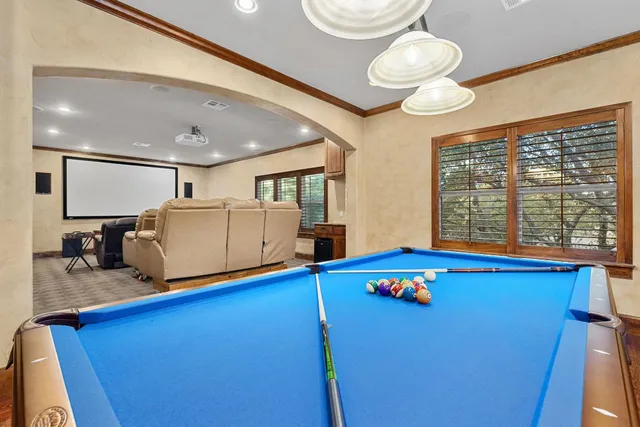 a room with pool table and windows
