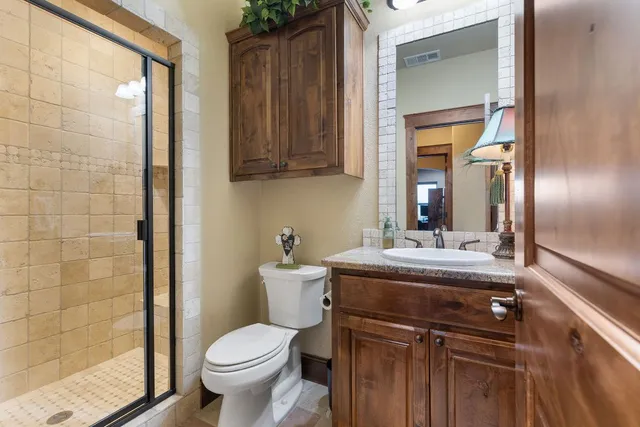 a bathroom with a sink vanity mirror and toilet