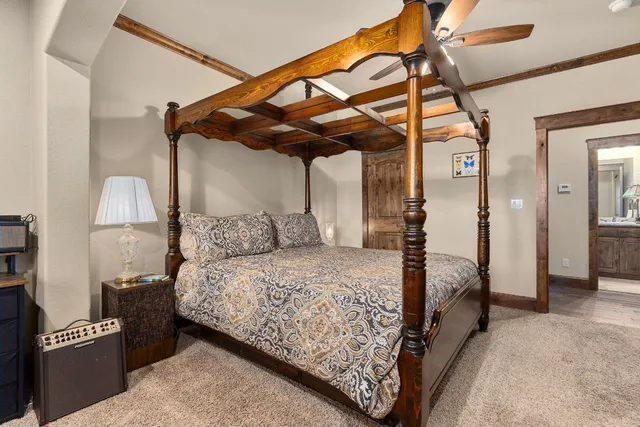 a view of a livingroom with a large window and chandelier fan
