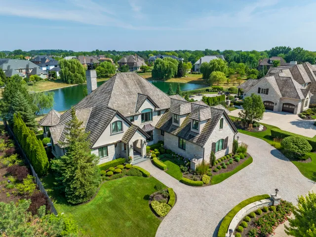 an aerial view of a house with a garden and lake view
