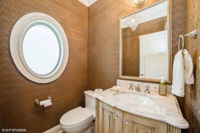 a bathroom with a granite countertop toilet a sink and a mirror
