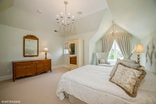 a spacious bedroom with a bed and a chandelier