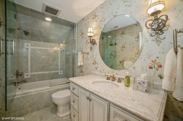 a bathroom with a granite countertop sink a toilet and shower