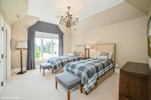 a bedroom with bed and a chandelier