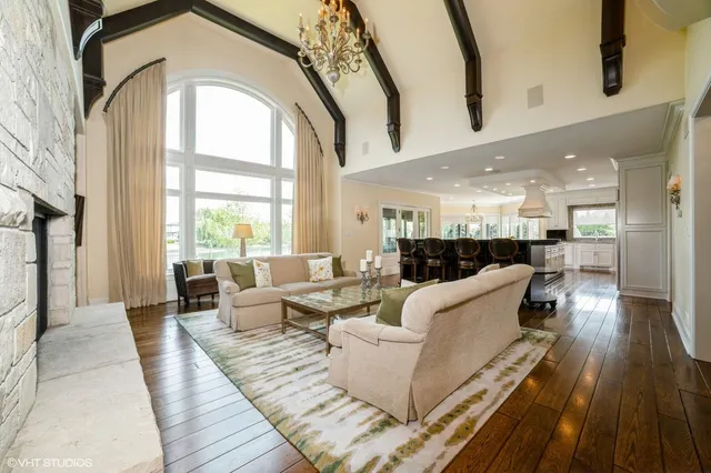 a living room with couches and kitchen view with wooden floor