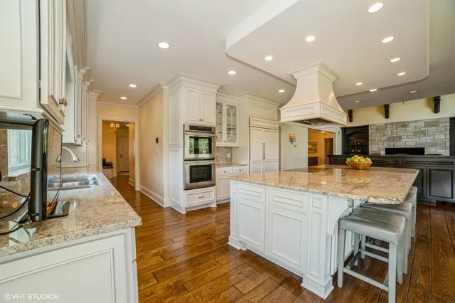a large kitchen with stainless steel appliances kitchen island granite countertop a large counter top and stove in it