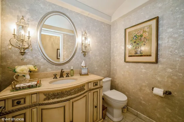 a bathroom with a granite countertop toilet a sink and a mirror