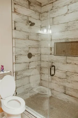 a bathroom with a granite countertop toilet sink and mirror