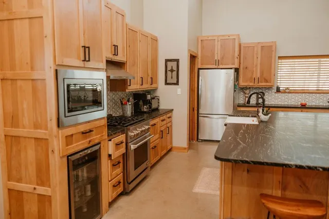 a kitchen with stainless steel appliances granite countertop a sink refrigerator and microwave