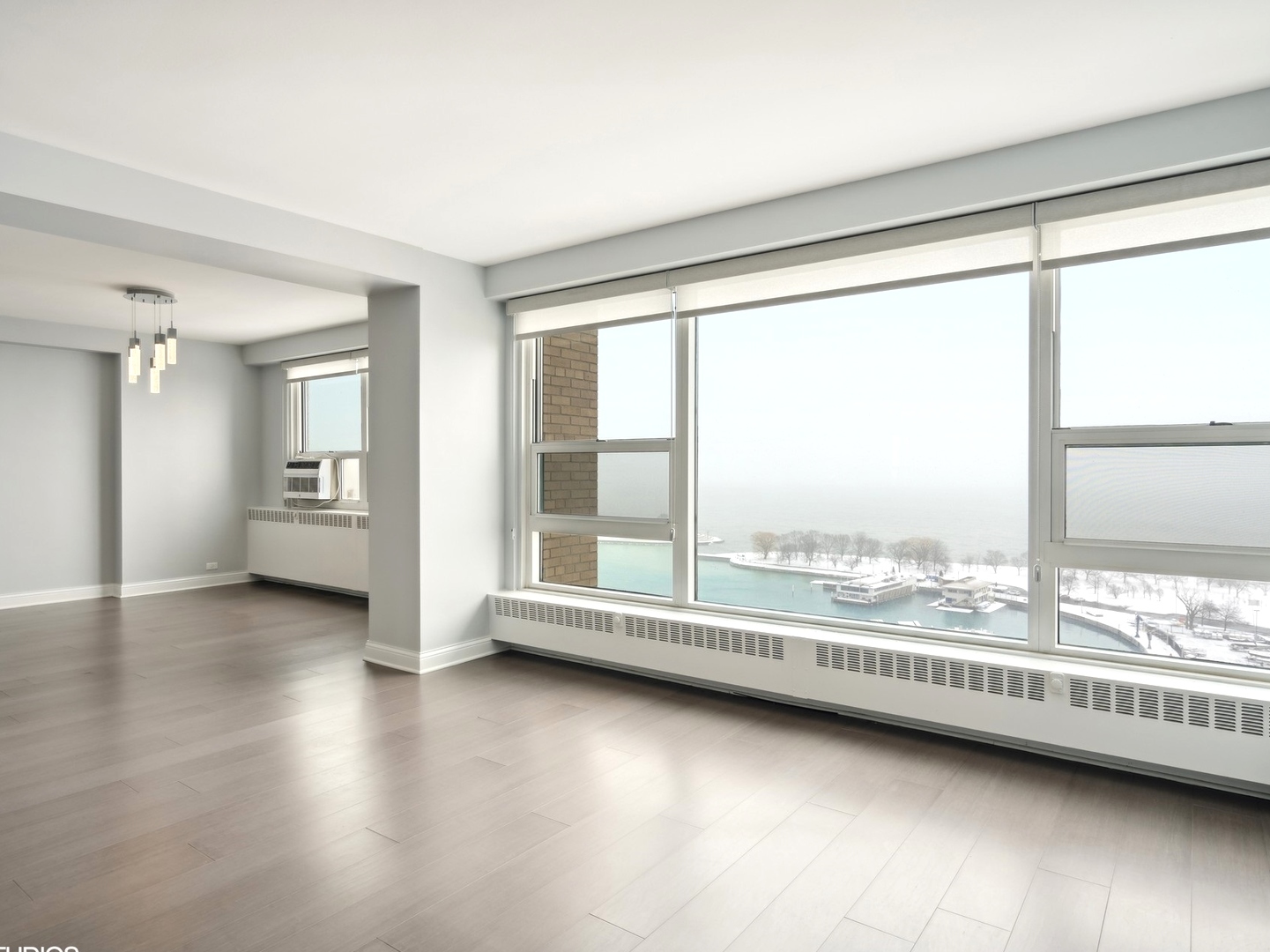 3180 North Lake Shore Drive, Unit 17E Chicago, IL 60657 - Photo 13 of 38 a view of an empty room with a window and wooden floor