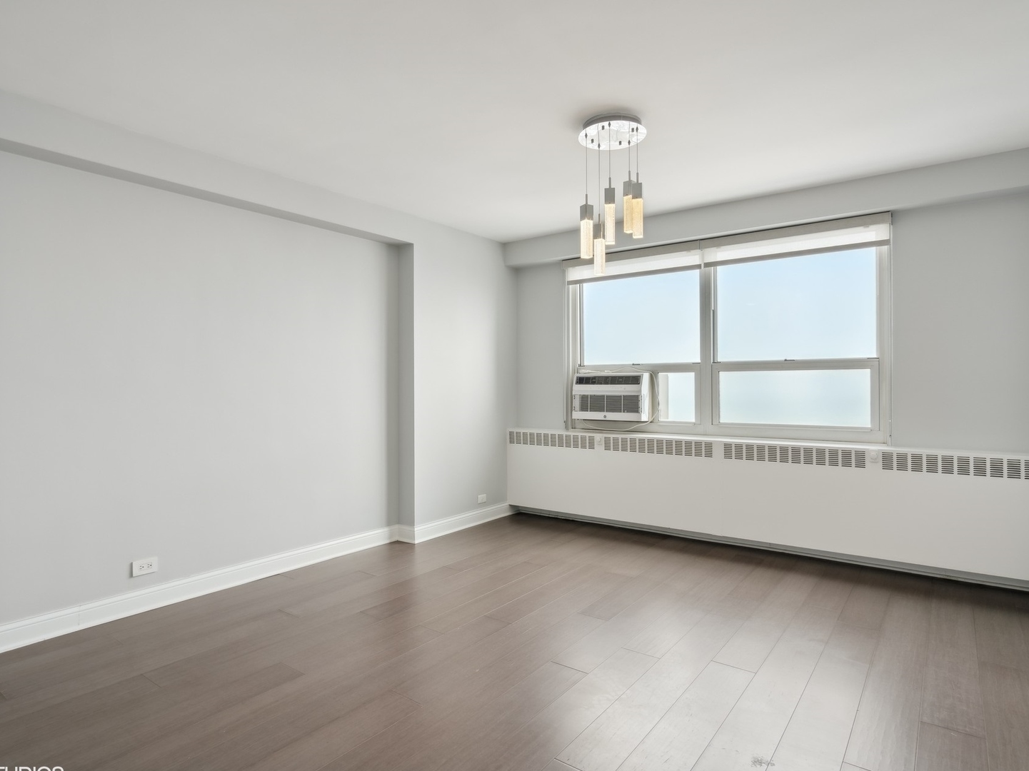 3180 North Lake Shore Drive, Unit 17E Chicago, IL 60657 - Photo 26 of 38 an empty room with wooden floor and windows