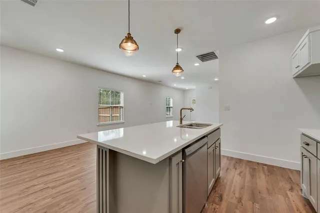 a kitchen with a sink a counter space and wooden floor