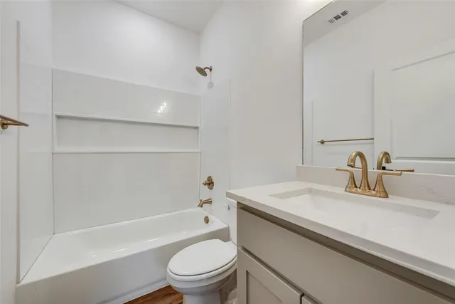 a bathroom with a sink toilet vanity and shower