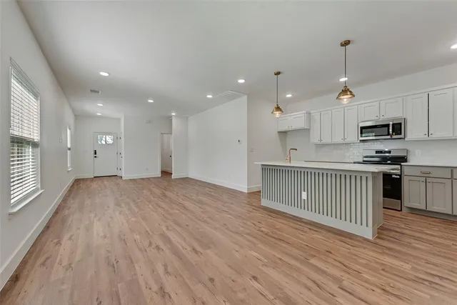a view of kitchen with granite countertop cabinets and wooden floor