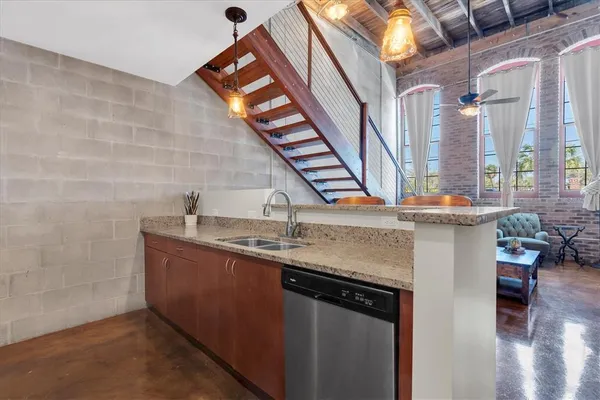 a kitchen with stainless steel appliances granite countertop a sink and a wooden floor