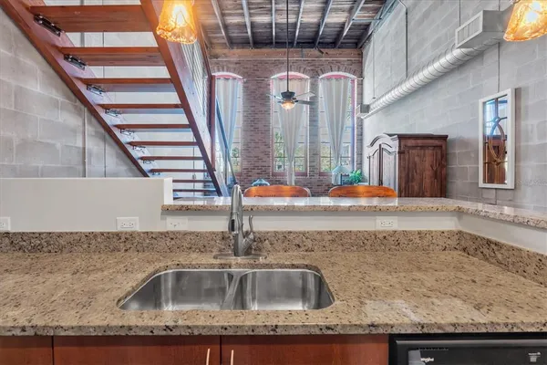 a kitchen with granite countertop a sink and cabinets