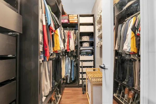 a view of walk in closet with clothes and shoes