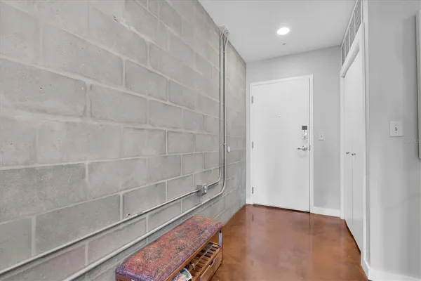 a view of a room with wooden floor and brick walls