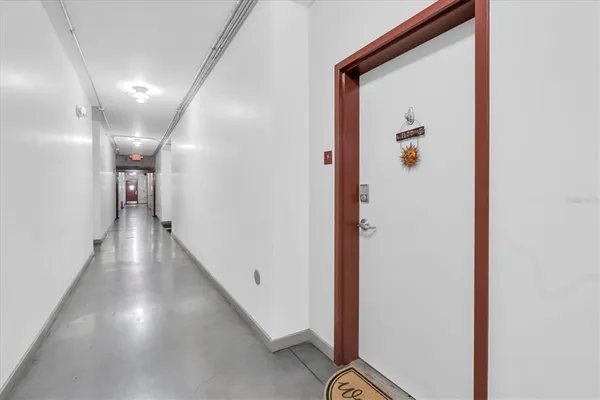 a view of a hallway with wooden floor
