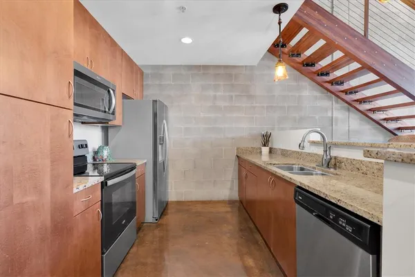 a kitchen with stainless steel appliances granite countertop a sink stove and refrigerator