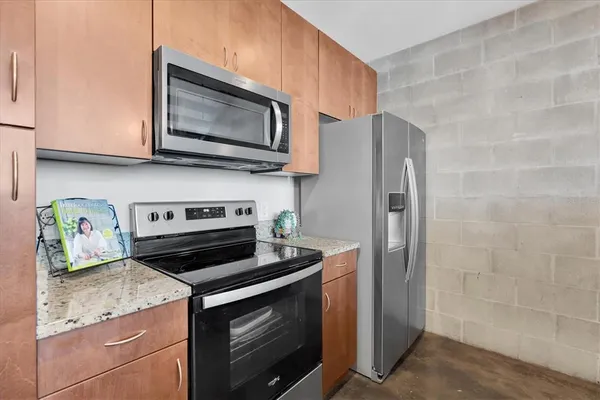 a kitchen with stainless steel appliances granite countertop a stove microwave refrigerator and sink