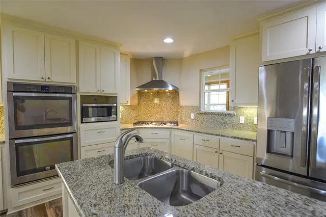 a kitchen with stainless steel appliances granite countertop a sink stove and refrigerator