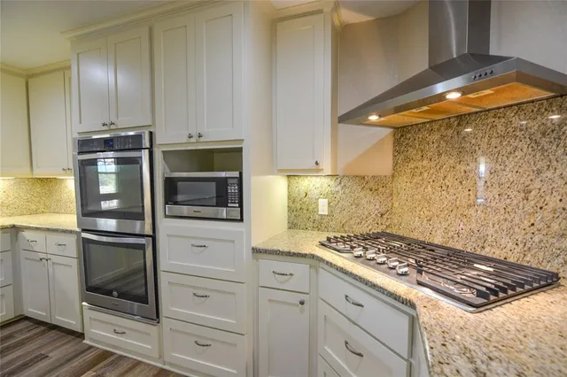 a kitchen with white cabinets and appliances