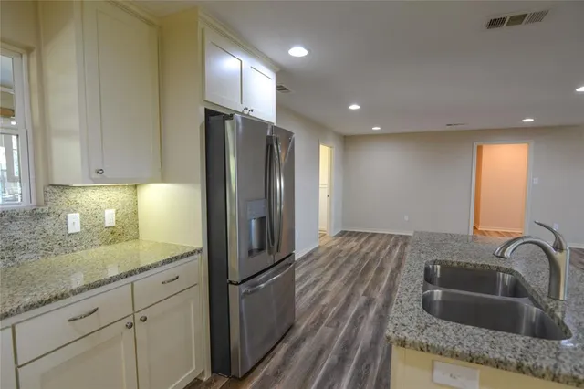 a kitchen with kitchen island granite countertop a sink stainless steel appliances and cabinets