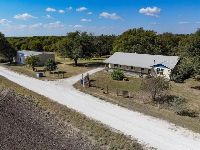a view of a patio with a table and chairs under an umbrella