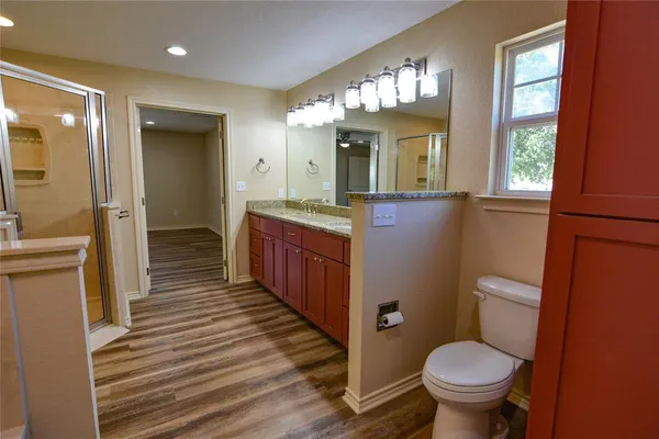 a bathroom with a sink a toilet a mirror and window