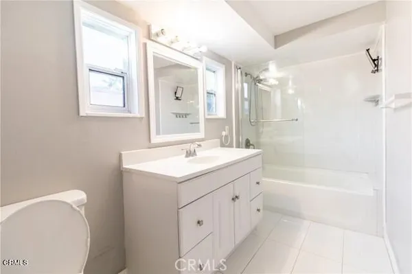 a bathroom with a bathtub shower sink vanity and toilet