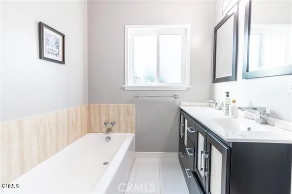 a bathroom with a tub a sink and a window